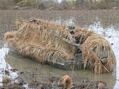 A boat covered in grass and mud.
